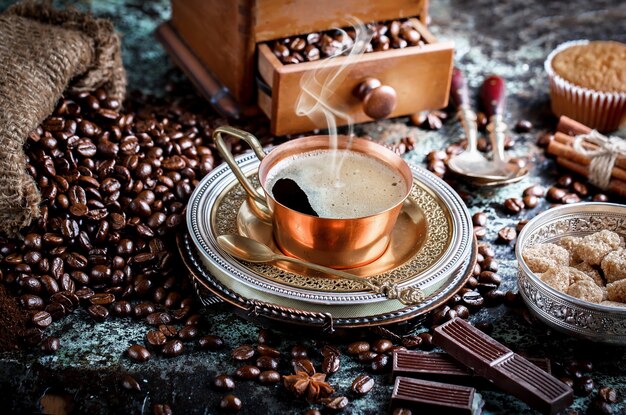 Café en una taza y platillo sobre un fondo antiguo