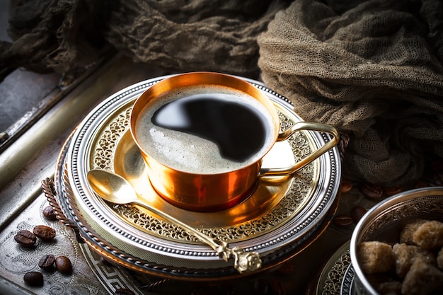 Café en una taza y platillo sobre un fondo antiguo