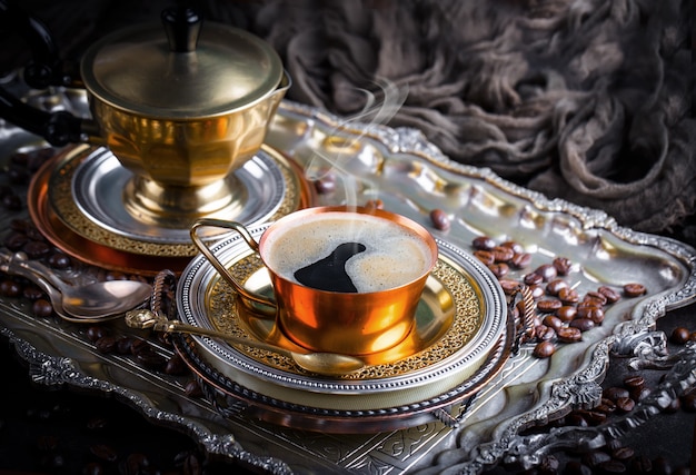 Café en una taza y platillo sobre un fondo antiguo