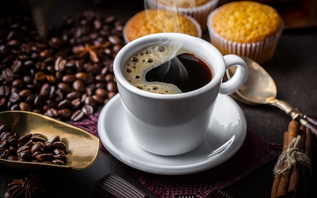 Café en una taza y platillo sobre un fondo negro