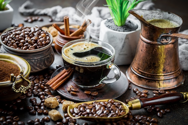 Café en una taza y platillo sobre un fondo negro