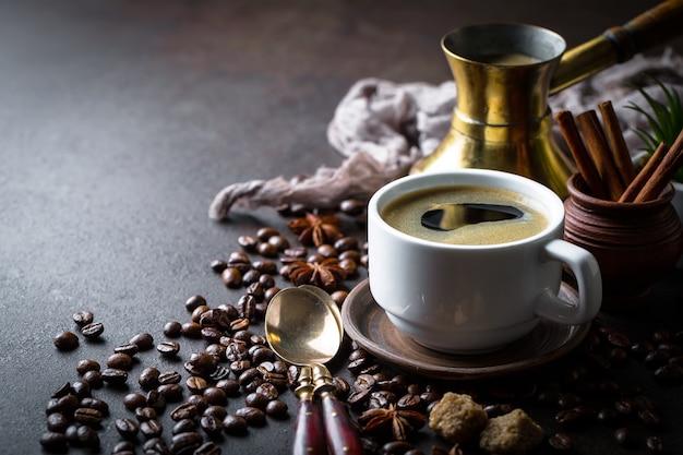 Café en una taza y platillo sobre un fondo negro