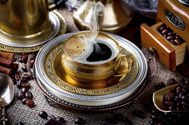 Café en una taza y platillo en un viejo.