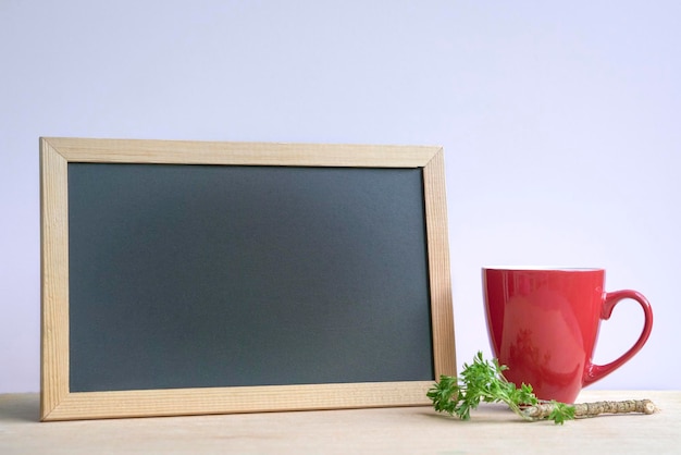 Café en taza roja con pizarra en blanco