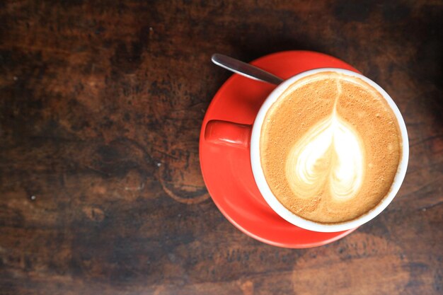 Café en taza roja sobre fondo de madera con textura oscura grunge antiguo