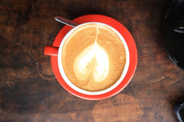 Café en taza roja sobre fondo de madera con textura oscura grunge antiguo