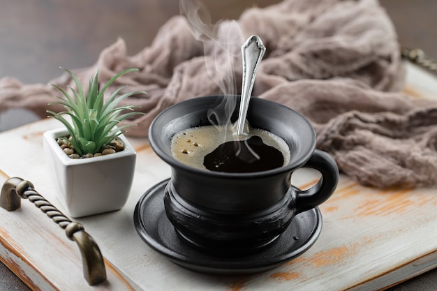 Café en una taza sobre un fondo de granos de café, sobre un fondo antiguo