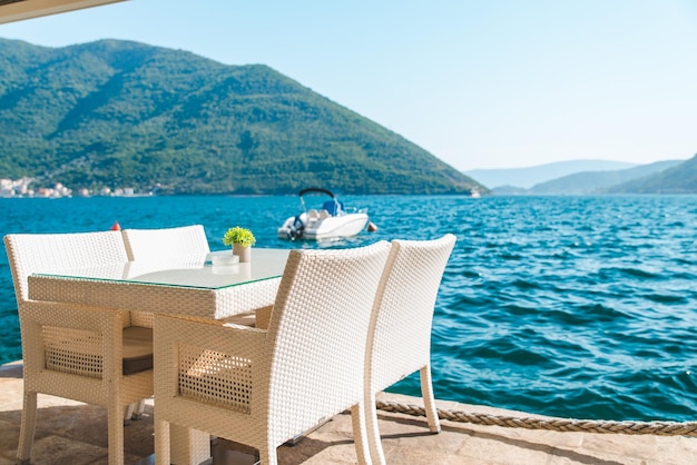 Café-Tisch am Strand mit schöner Aussicht auf Meer und Berge