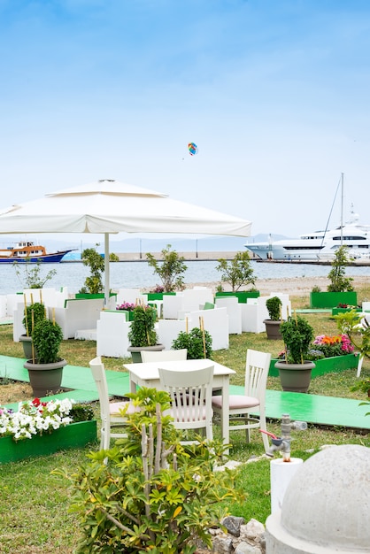 Cafe Tische serviert mit einem weißen Tischtuch in der Nähe der Küste für erholsame Ferien Urlaub