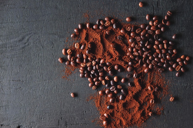 Café tostado en grano y café molido en polvo sobre un fondo negro