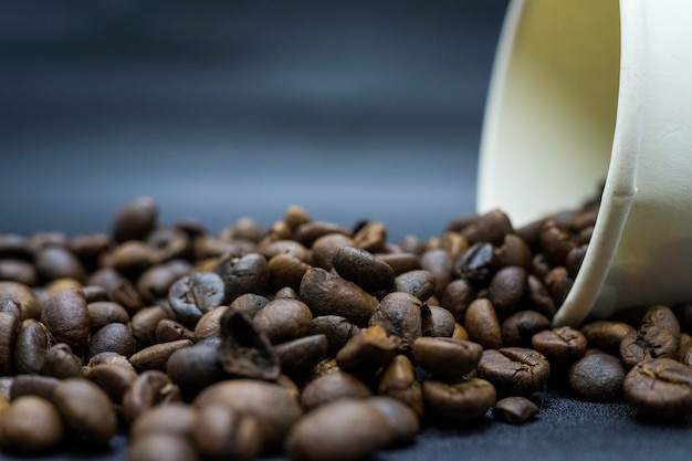 Café tostado en grano y recipiente de papel