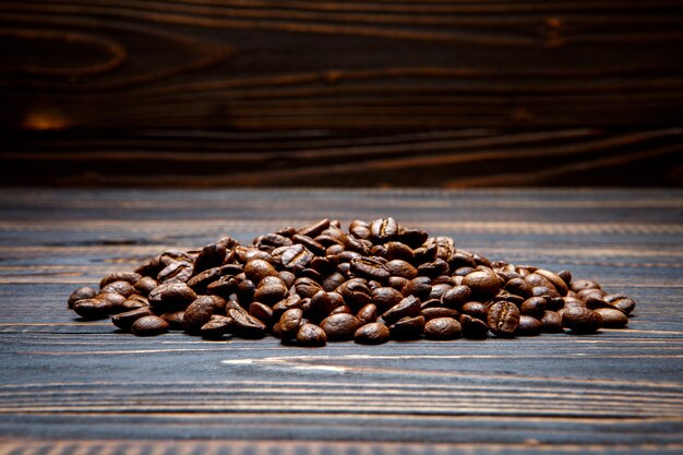 Café tostado en grano sobre fondo de madera