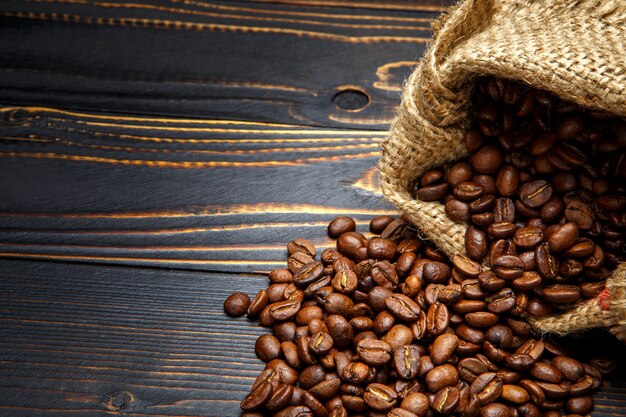 Café tostado en grano sobre fondo de madera