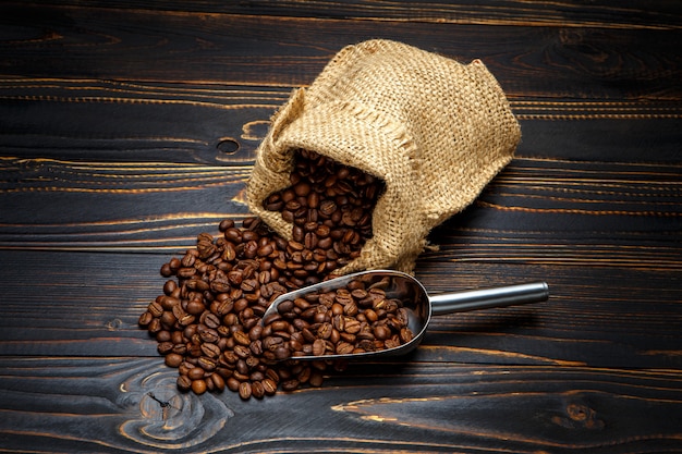 Café tostado en grano sobre fondo de madera