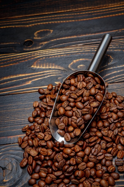 Café tostado en grano sobre fondo de madera