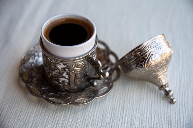 Café turco en una hermosa taza tradicional con una tapa elegante Hermosa porción de café en un café turco