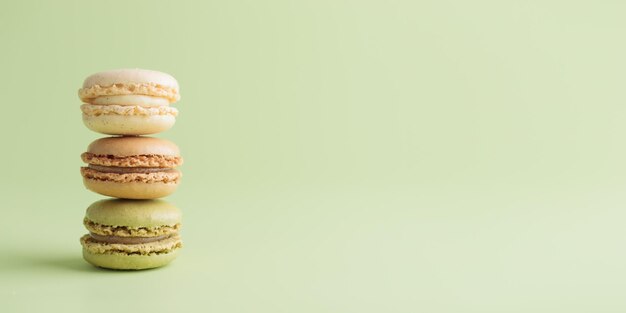 Café de vainilla y macarrones hechos a mano ecológicos de color pastel de pistacio sobre fondo verde Regalo para el 8 de marzo Día Internacional de la Mujer Día de San Valentín