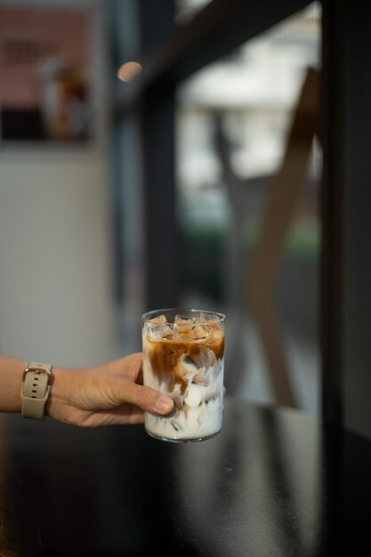 Foto café en un vaso en una mesa en una cafetería