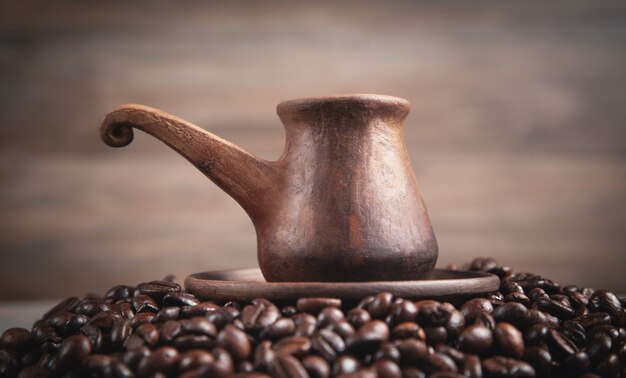 Cafetera de arcilla en granos de café.
