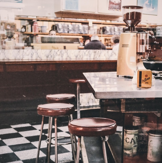 Cafetera en la mesa junto a los asientos en la cafetería