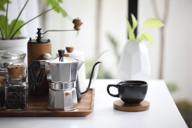 Cafetera moka de aluminio y taza de café negra con café