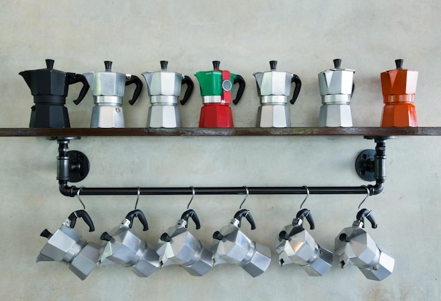 Cafetera moka italiana colgada en la pared de cemento