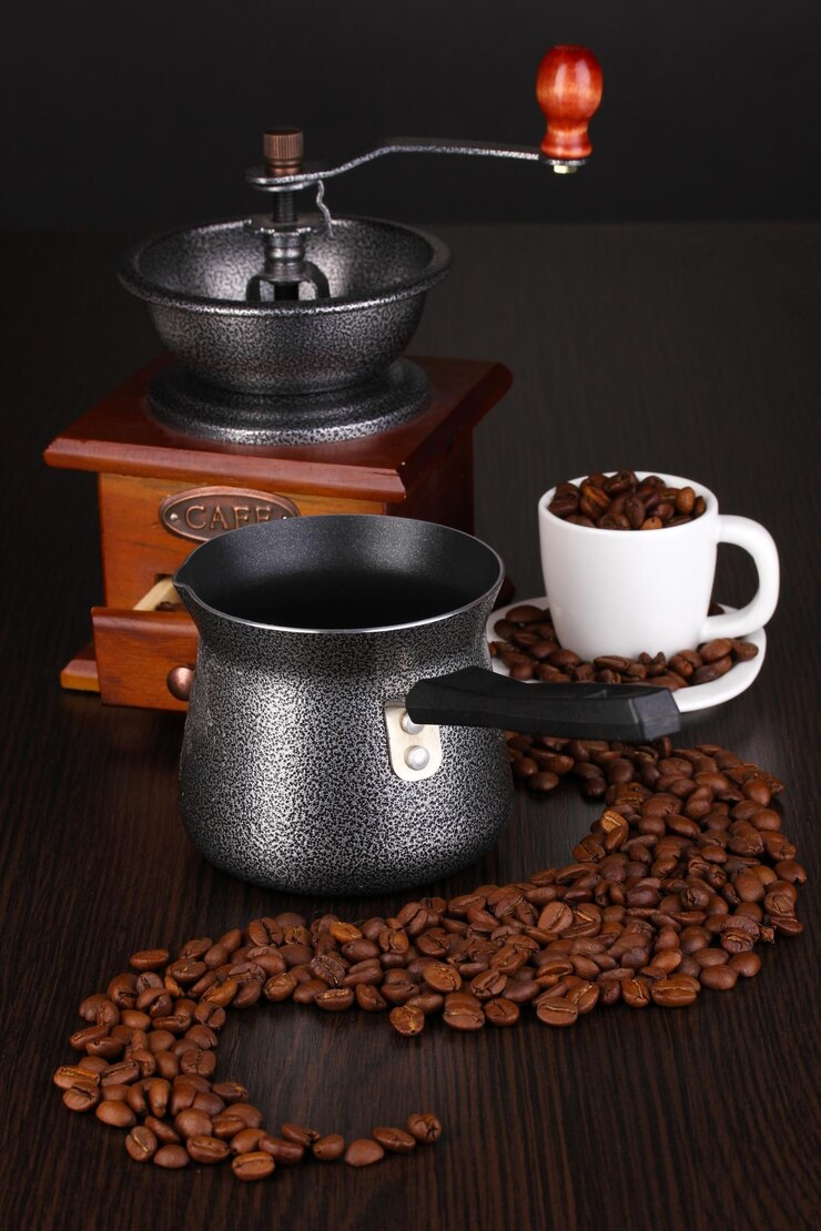 Foto cafetera y molinillo de café en mesa marrón
