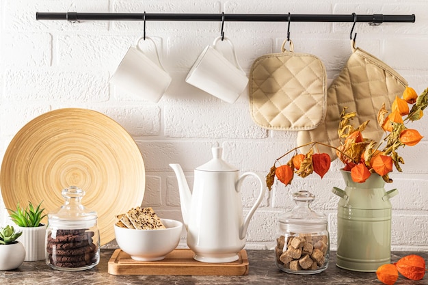 Cafetera de porcelana blanca latas de azúcar y galletas de granos de café en un tazón cocina fondo moderno