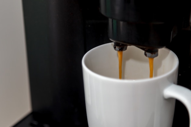 Cafetera vierte café en una taza