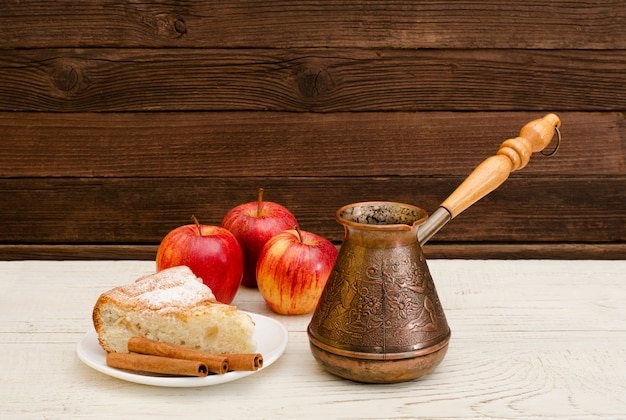 Cafeteras, tarta de manzana, canela y manzanas maduras