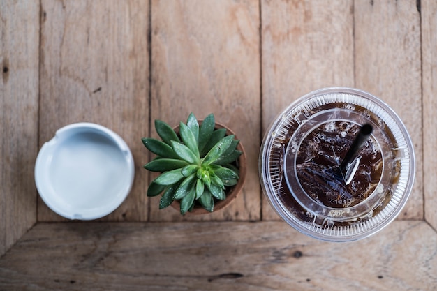 cafetería de fondo, la planta de café y cenicero en la mesa de madera en la cafetería