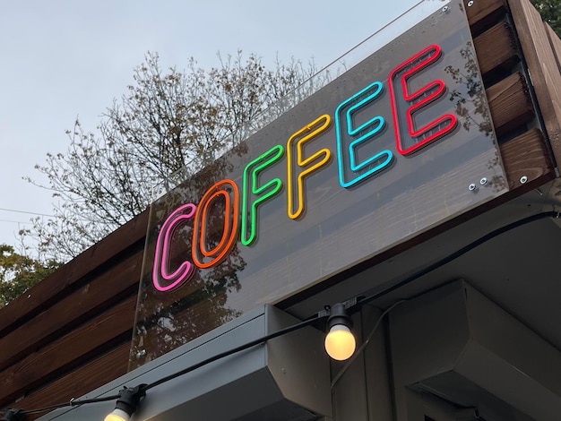 Foto cafetería letrero de neón que brilla intensamente durante el día