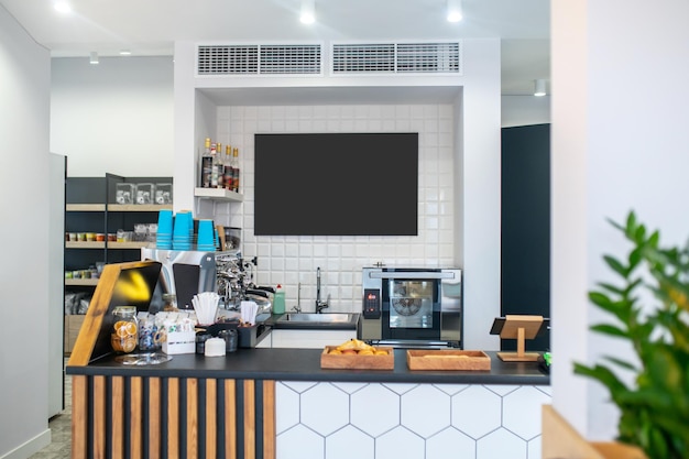 Cafetería. Pequeña barra de bar con platos, cafetera y bollería fresca en una cafetería limpia y acogedora sin gente