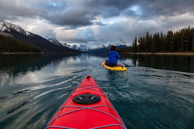 Caiaque e Paddle Boarding em um lago glacial tranquilo com as Montanhas Rochosas canadenses