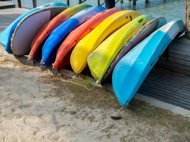 Caiaque multicolorido na praia arenosa, prepare-se para hóspedes de hotéis ou resorts em viagens de férias de verão