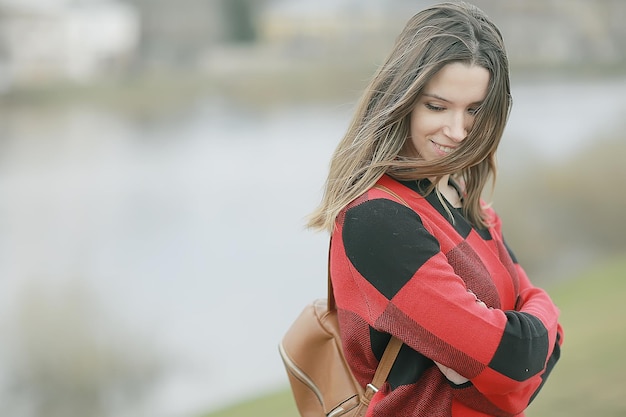 Caída de cabello al aire libre / retrato de otoño modelo de niña adulta mujer con cabello largo en un día ventoso en el parque