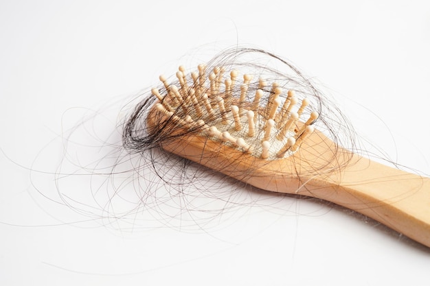 Caída de la caída del cabello con peine cepillo aislado sobre fondo blanco.