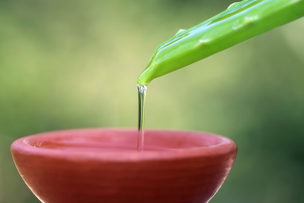 Caída de extracto de aloe vera en un recipiente marrón