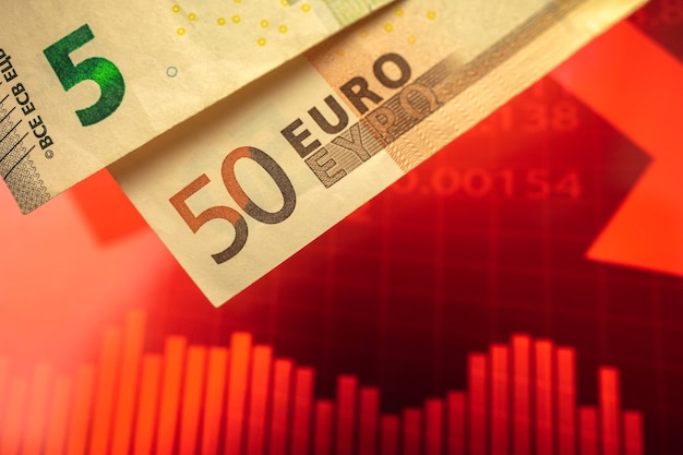 Caída del gráfico de la moneda del euro, colapso y crisis en el fondo del concepto de unión de Europa con la flecha roja hacia abajo