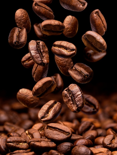 Foto caída de granos de café. oscuro con espacio de copia