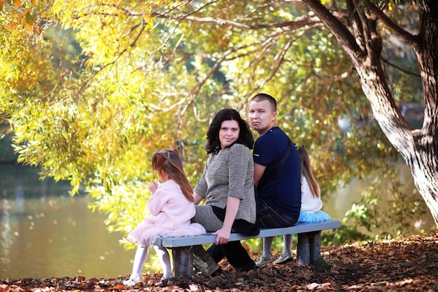 Caída de hojas en el parque. Niños a pasear por el parque de otoño. Familia. Otoño. Felicidad.