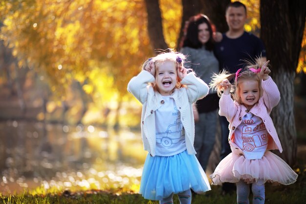 Caída de hojas en el parque. Niños a pasear por el parque de otoño. Familia. Otoño. Felicidad.