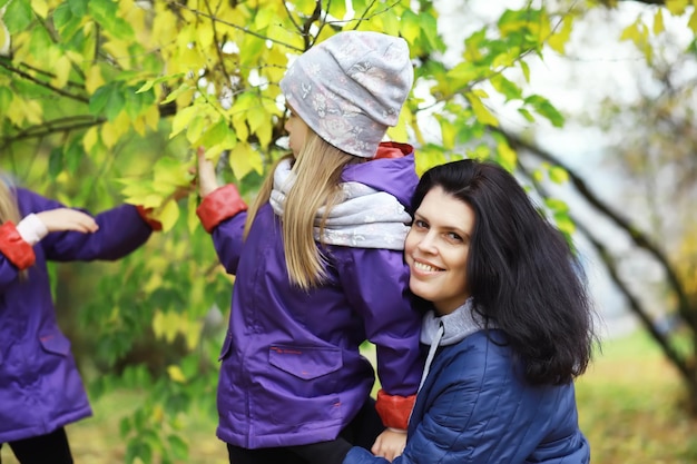 Caída de hojas en el parque. Niños a pasear por el parque de otoño. Familia. Otoño. Felicidad.