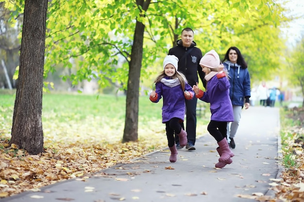 Caída de hojas en el parque. Niños a pasear por el parque de otoño. Familia. Otoño. Felicidad.