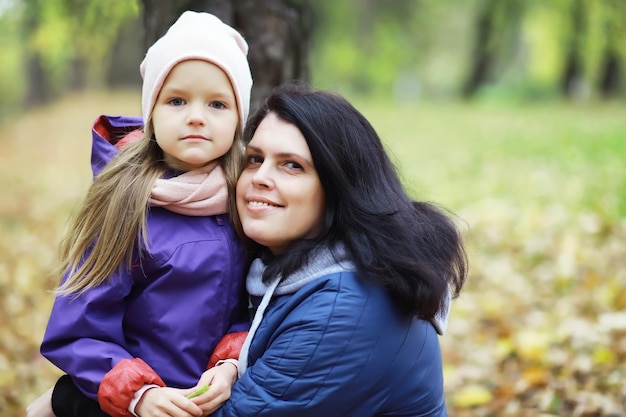 Caída de hojas en el parque. Niños a pasear por el parque de otoño. Familia. Otoño. Felicidad.