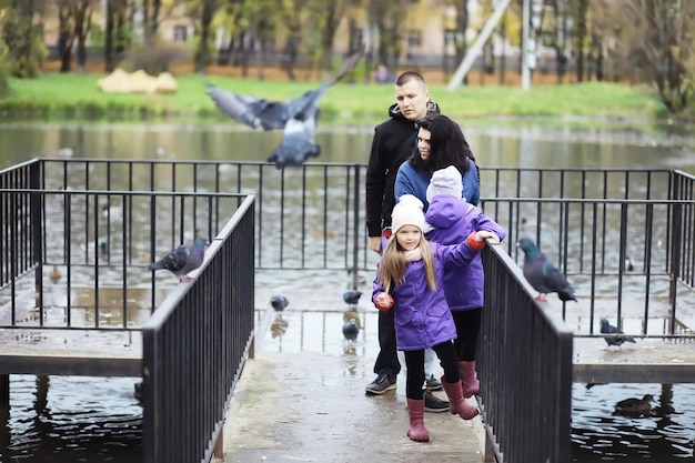 Caída de hojas en el parque. Niños a pasear por el parque de otoño. Familia. Otoño. Felicidad.