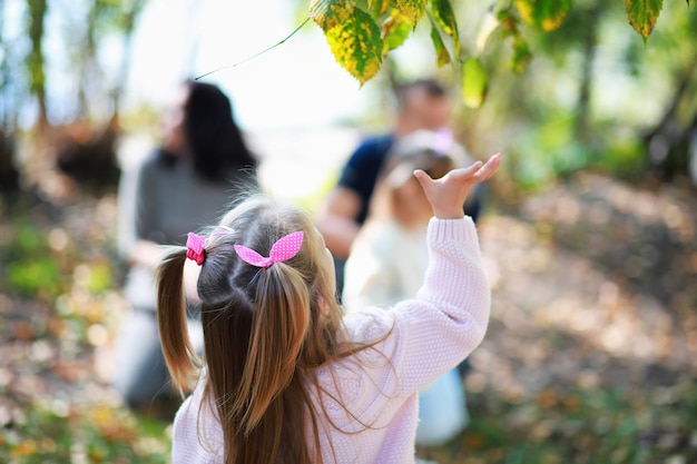 Caída de hojas en el parque. Niños a pasear por el parque de otoño. Familia. Otoño. Felicidad.