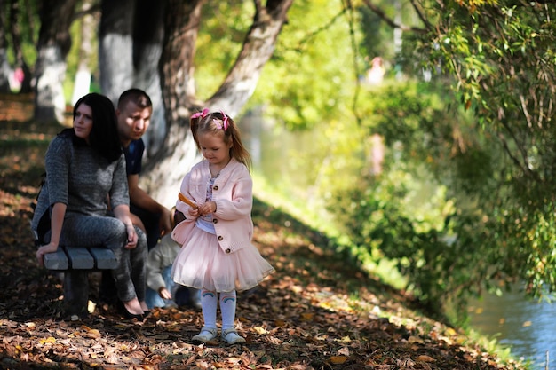 Caída de hojas en el parque. Niños a pasear por el parque de otoño. Familia. Otoño. Felicidad.