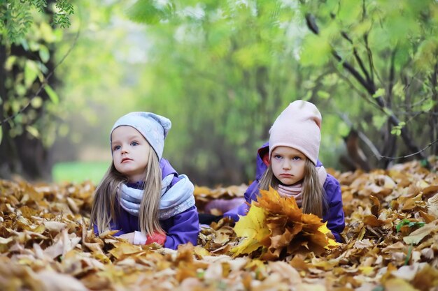 Caída de hojas en el parque Niños de paseo en el parque de otoño Familia Otoño Felicidad