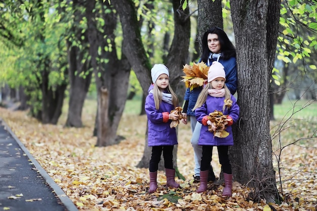 Caída de hojas en el parque Niños de paseo en el parque de otoño Familia Otoño Felicidad